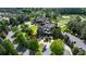 An aerial view captures a golf course view home with mature trees, landscape, and circular drive at 938 Crescent River Pass, Suwanee, GA 30024