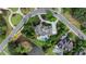 An aerial view captures an estate with a pool, lush lawns, gardens, and a winding road at 938 Crescent River Pass, Suwanee, GA 30024