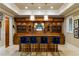This handsome bar features custom cabinetry, lighting, and seating for four at 938 Crescent River Pass, Suwanee, GA 30024