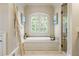 Bathroom showcases a soaking tub, window with blinds, and a glass enclosed shower at 938 Crescent River Pass, Suwanee, GA 30024