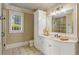 Elegant bathroom with granite countertop, framed mirror, decorative lighting, and stand up shower at 938 Crescent River Pass, Suwanee, GA 30024