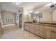 Bright bathroom featuring double sink vanity, soaking tub, and neutral tile flooring at 938 Crescent River Pass, Suwanee, GA 30024