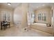 Elegant bathroom with a soaking tub, decorative chair, and tiled floor at 938 Crescent River Pass, Suwanee, GA 30024