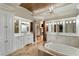 Elegant bathroom with double vanities, a soaking tub, and wood ceiling at 938 Crescent River Pass, Suwanee, GA 30024