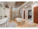 A large bathroom with dual sinks, a stand-alone tub and a frameless glass shower with lots of natural light at 938 Crescent River Pass, Suwanee, GA 30024