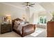 Comfortable bedroom featuring large bed, ceiling fan and window seat at 938 Crescent River Pass, Suwanee, GA 30024