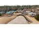 An aerial view of the community clubhouse with tennis courts, a pool, a playground, and a bridge over the pond at 938 Crescent River Pass, Suwanee, GA 30024