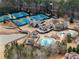 An aerial view of a community center featuring tennis courts, pool, water park, clubhouse, and outdoor areas at 938 Crescent River Pass, Suwanee, GA 30024