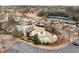 An aerial view shows the community pool, clubhouse, kiddie pool, waterslide, and surrounding landscaping at 938 Crescent River Pass, Suwanee, GA 30024