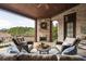 Covered patio with outdoor fireplace, comfortable seating, and a view of the lake at 938 Crescent River Pass, Suwanee, GA 30024