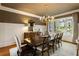 Elegant dining room featuring wainscoting, a sophisticated chandelier, and large windows with natural light at 938 Crescent River Pass, Suwanee, GA 30024