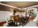 Sophisticated dining area with wainscoting, a modern chandelier, and hardwood flooring at 938 Crescent River Pass, Suwanee, GA 30024