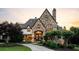 Spectacular stone home featuring a custom circular driveway and lush landscaping at 938 Crescent River Pass, Suwanee, GA 30024