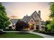 Stunning stone home with manicured lawn, lush landscaping, and a charming circular driveway at 938 Crescent River Pass, Suwanee, GA 30024