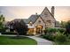 Elegant stone home with beautiful landscaping, mature trees, and a welcoming circular driveway at 938 Crescent River Pass, Suwanee, GA 30024