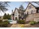 Exterior view of a brick two-story home with a pool, hot tub, manicured lawn and professional landscaping at 938 Crescent River Pass, Suwanee, GA 30024