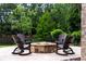 Stone firepit with Adirondack chairs on a stone patio surrounded by lush greenery at 938 Crescent River Pass, Suwanee, GA 30024