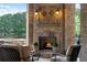Stone fireplace on covered patio with ornate lanterns and a view of the outdoor spa at 938 Crescent River Pass, Suwanee, GA 30024