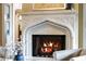 Stone fireplace with a detailed mantel and a cozy fire burning inside at 938 Crescent River Pass, Suwanee, GA 30024