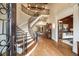 Elegant foyer with curved staircase, wood floors, and view into the formal living room at 938 Crescent River Pass, Suwanee, GA 30024