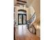 Stunning foyer with a curved staircase, iron-detailed door, and gleaming hardwood floors at 938 Crescent River Pass, Suwanee, GA 30024