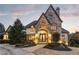 Majestic stone facade with an arched entry, double doors, and manicured landscaping at 938 Crescent River Pass, Suwanee, GA 30024