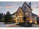 An impressive stone exterior with an arched entryway and stylish double doors at 938 Crescent River Pass, Suwanee, GA 30024