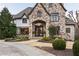 Handsome stone home with arched entry and stately front landscaping at 938 Crescent River Pass, Suwanee, GA 30024