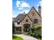 Stone and brick home exterior featuring an arched entryway and manicured landscaping at 938 Crescent River Pass, Suwanee, GA 30024