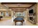 The game room has a billiard table, stone fireplace, wood beams, and a view to the outside at 938 Crescent River Pass, Suwanee, GA 30024