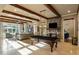 This large game room has stone fireplace, exposed beams, and a beautiful billiard table, as well as a view to a sitting room at 938 Crescent River Pass, Suwanee, GA 30024