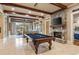 Spacious game room with a pool table, a stone fireplace, and a large window view at 938 Crescent River Pass, Suwanee, GA 30024