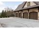 Spacious three-car garage with arched doors and a concrete driveway in a beautiful home exterior at 938 Crescent River Pass, Suwanee, GA 30024