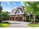 Spacious three-car garage featuring brick and stone accents with a driveway at 938 Crescent River Pass, Suwanee, GA 30024