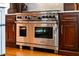 A stainless steel Wolf range is set in beautiful dark wood cabinets at 938 Crescent River Pass, Suwanee, GA 30024