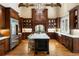 Gourmet kitchen features dark wood cabinets, large island, and stainless appliances at 938 Crescent River Pass, Suwanee, GA 30024