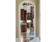 Open arched doorway to a kitchen with dark wood cabinets and stainless steel appliances at 938 Crescent River Pass, Suwanee, GA 30024