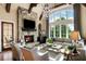 Cozy living room featuring a stone fireplace, large windows, and wood beams at 938 Crescent River Pass, Suwanee, GA 30024