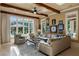 This comfortable living room has a large sectional sofa, beautiful windows, and access to the outdoor pool at 938 Crescent River Pass, Suwanee, GA 30024