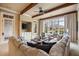 Bright living room featuring coffered ceilings, large windows, and a comfortable sectional sofa at 938 Crescent River Pass, Suwanee, GA 30024