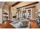 Elegant living room with fireplace, wood beams, hardwood floors, and stylish furnishings at 938 Crescent River Pass, Suwanee, GA 30024