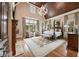 Spacious main bedroom with hardwood floors, coffered wood ceiling, four-poster bed, sitting area, and large windows at 938 Crescent River Pass, Suwanee, GA 30024