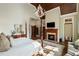 Spacious main bedroom featuring hardwood floors, a fireplace, and a four-poster bed at 938 Crescent River Pass, Suwanee, GA 30024