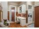 Mud room with built-in desk, storage cabinets, wood paneling, and access to the laundry room at 938 Crescent River Pass, Suwanee, GA 30024