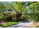 Stone outbuilding featuring wood supports and a stone-paved driveway at 938 Crescent River Pass, Suwanee, GA 30024