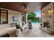 Covered brick patio with fireplace, comfortable seating, ceiling fan, and a view of the lovely pool at 938 Crescent River Pass, Suwanee, GA 30024