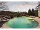 A backyard with a waterfall pool surrounded by lush landscaping at 938 Crescent River Pass, Suwanee, GA 30024