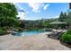 Backyard pool with waterfall feature, spa and lounge chairs surrounded by lush landscaping at 938 Crescent River Pass, Suwanee, GA 30024