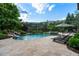 Beautiful pool with waterfall feature and spa surrounded by lush landscaping and patio seating at 938 Crescent River Pass, Suwanee, GA 30024
