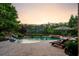 Resort-style pool area with stone patio, waterfall feature, spa and comfortable lounge chairs at 938 Crescent River Pass, Suwanee, GA 30024